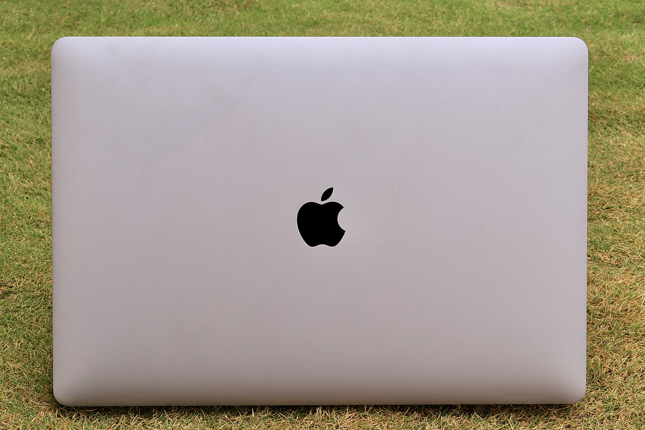 The lid of a MacBook Pro resting on grass